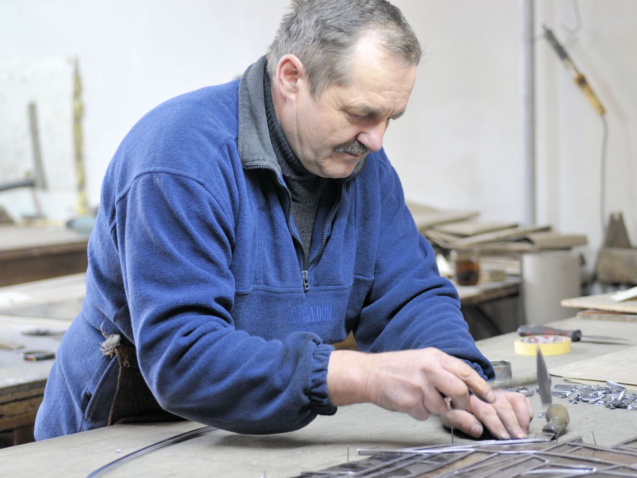 Older adult working in a workshop, representing vision after cataract surgery